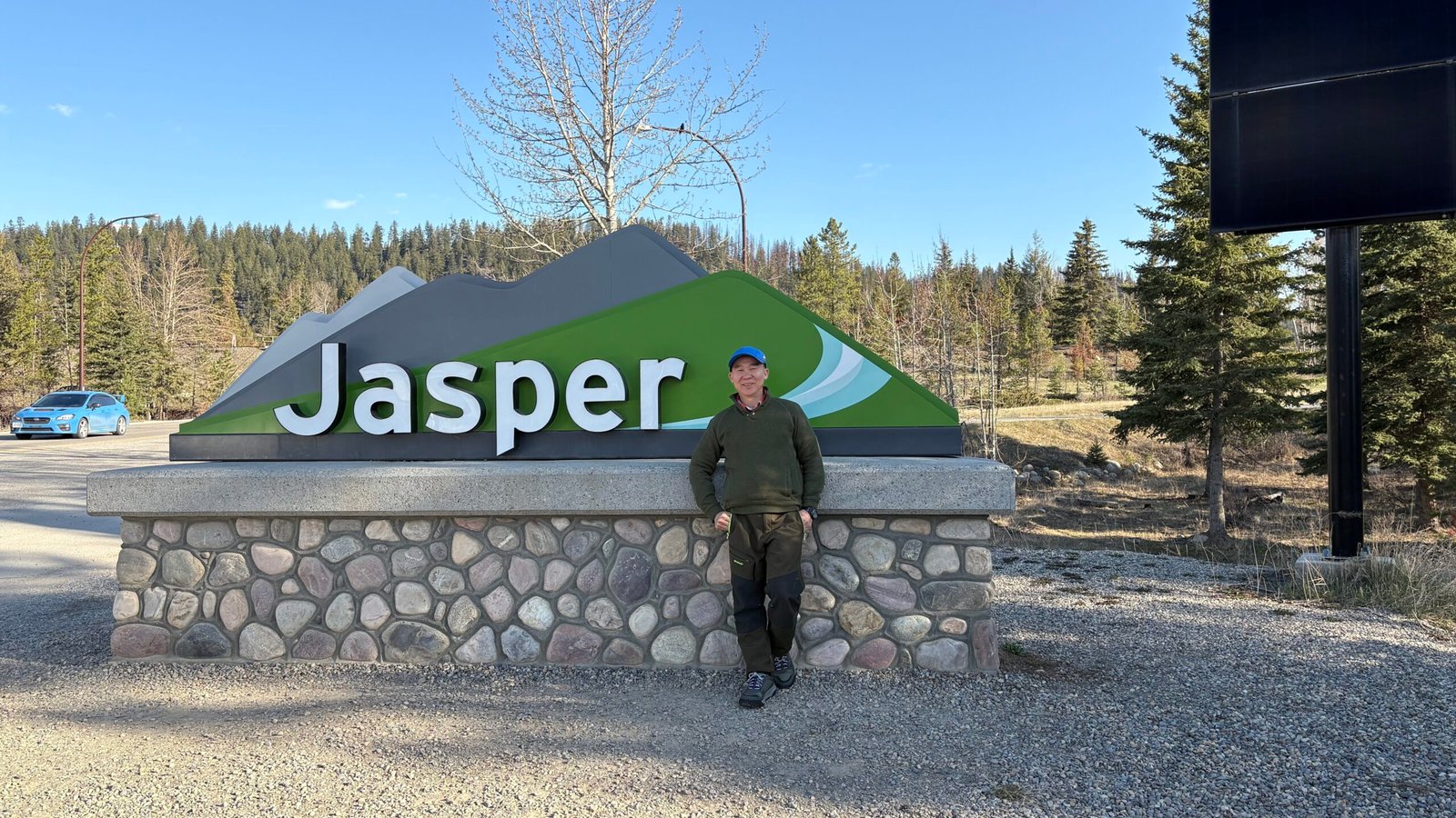 Sustainable Road Trip Guide - Stop 1 Steven is standing proudly at the iconic Jasper sign, surrounded by the breathtaking wilderness of the Canadian Rockies. This charming town is the heart of adventure—where mountain vistas, wildlife encounters, and endless exploration begin. Whether you're here for the hiking, the stargazing, or the cozy small-town vibes, Jasper never fails to inspire.